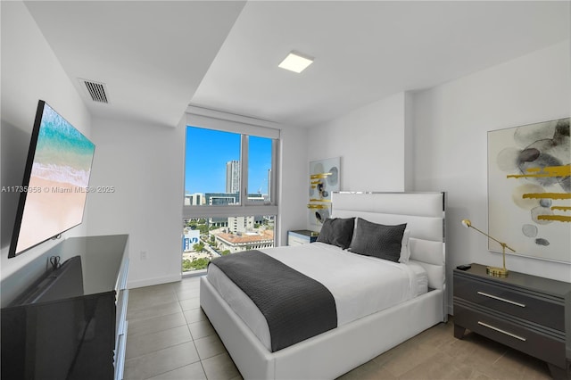 bedroom with floor to ceiling windows and light tile patterned floors