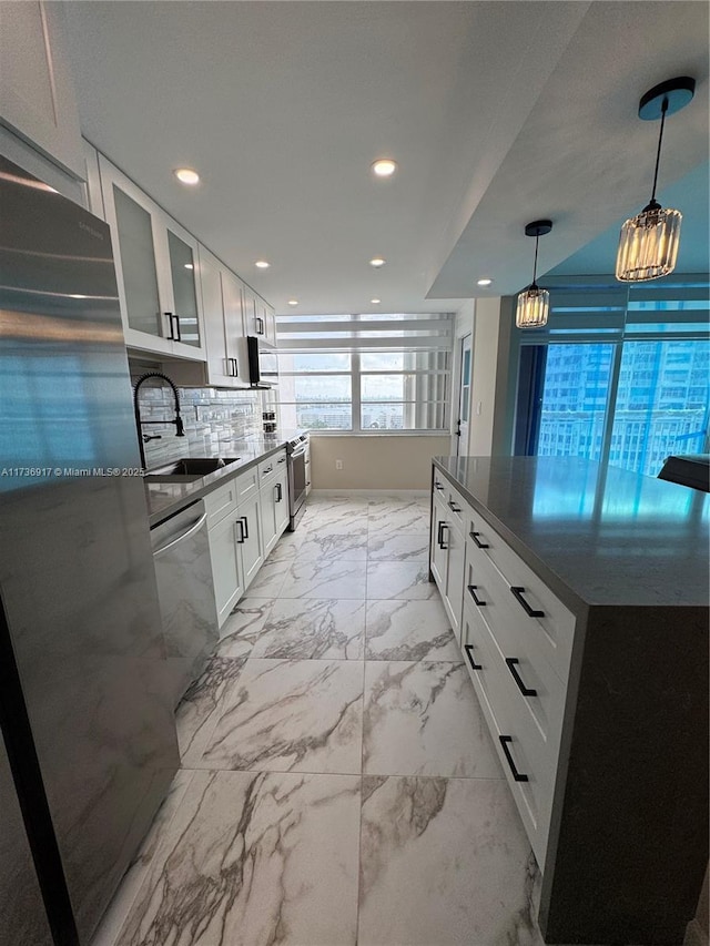 kitchen with white cabinets, glass insert cabinets, marble finish floor, stainless steel appliances, and a sink