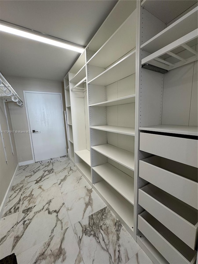 spacious closet featuring marble finish floor