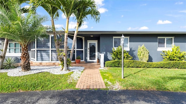 view of front of home featuring stucco siding and a front lawn