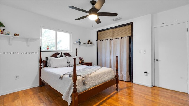 bedroom featuring light wood finished floors, visible vents, ceiling fan, and baseboards