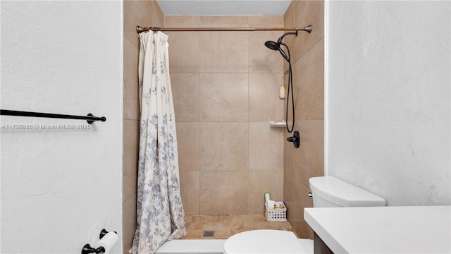 full bath with a stall shower, toilet, vanity, and a textured wall