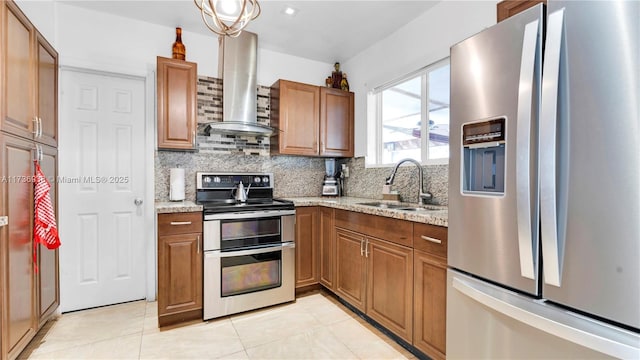 kitchen featuring a sink, tasteful backsplash, appliances with stainless steel finishes, and wall chimney range hood