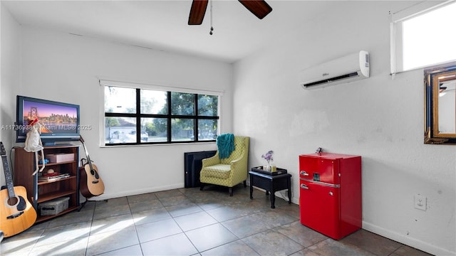 living area with tile patterned flooring, a wall mounted air conditioner, baseboards, and a ceiling fan