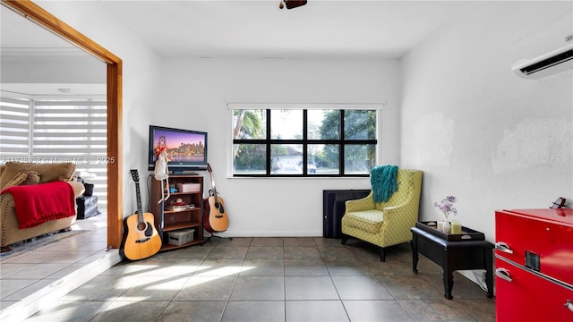 sitting room featuring a wall mounted air conditioner and tile patterned flooring