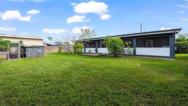 view of yard featuring fence and a sunroom