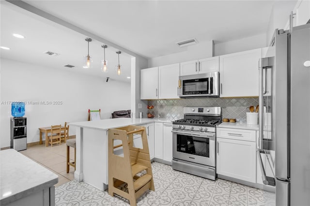 kitchen featuring appliances with stainless steel finishes, white cabinets, and kitchen peninsula