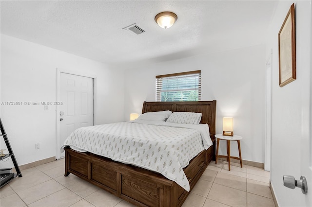 bedroom featuring light tile patterned floors and a textured ceiling