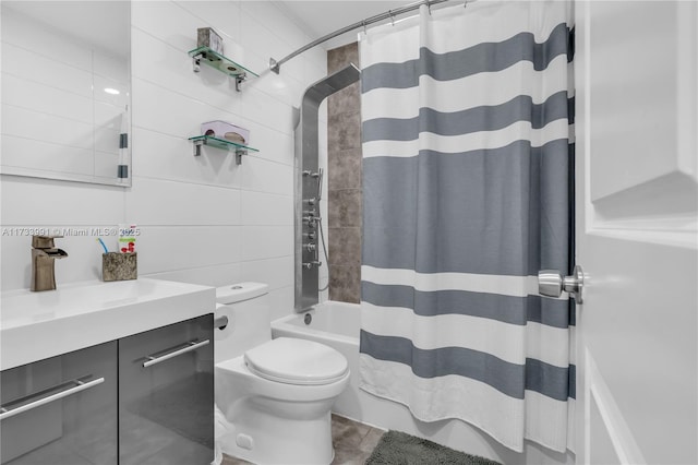 full bathroom with tile walls, vanity, toilet, and shower / tub combo with curtain