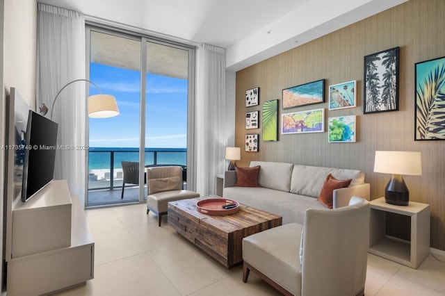 tiled living room featuring floor to ceiling windows and a water view