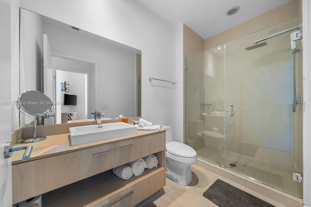 bathroom featuring walk in shower, vanity, toilet, and tile patterned flooring