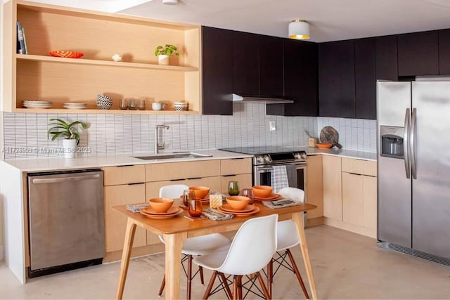 kitchen featuring stainless steel appliances, light brown cabinetry, sink, and backsplash