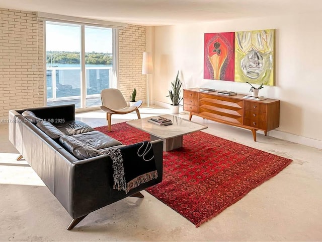 living room featuring a water view and brick wall