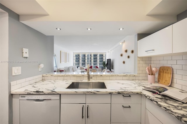 kitchen with white cabinetry, sink, white dishwasher, and decorative backsplash