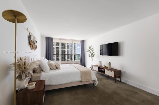 bedroom with dark colored carpet and floor to ceiling windows