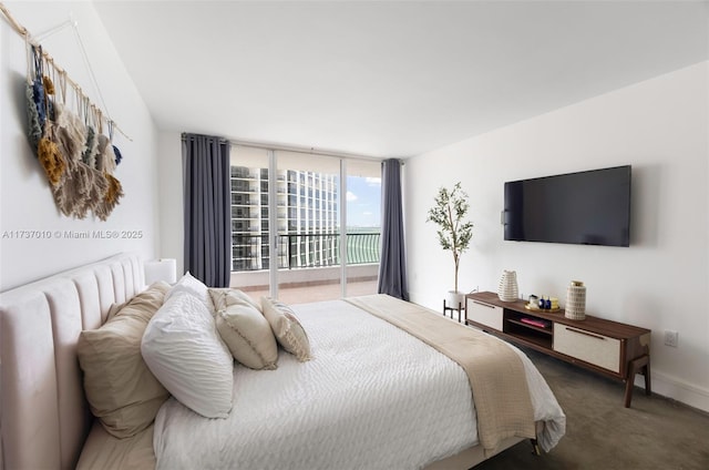 bedroom with expansive windows and dark colored carpet