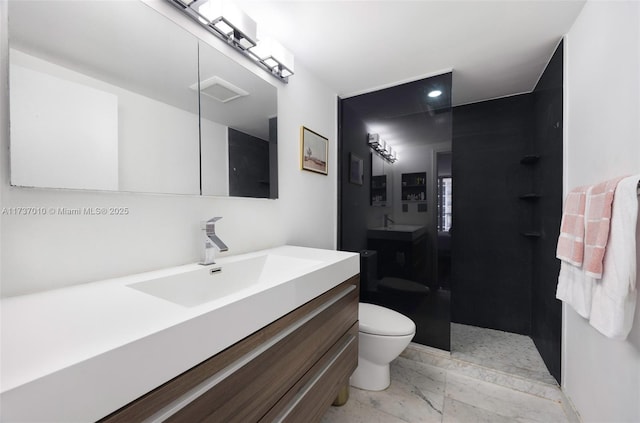 bathroom with walk in shower, vanity, and toilet