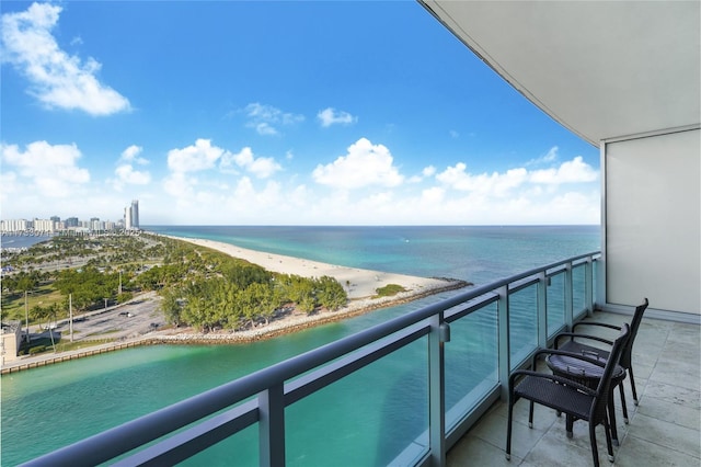 balcony featuring a water view and a beach view