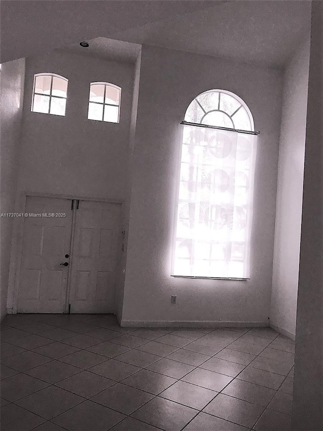 entryway with a high ceiling and light tile patterned flooring