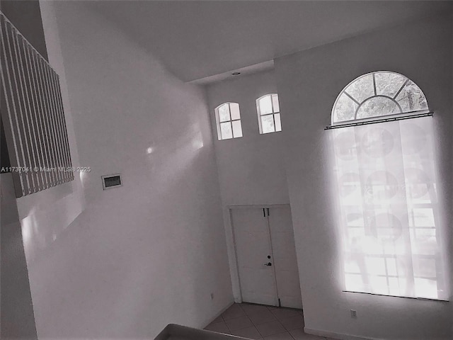 foyer entrance featuring a high ceiling and light tile patterned floors