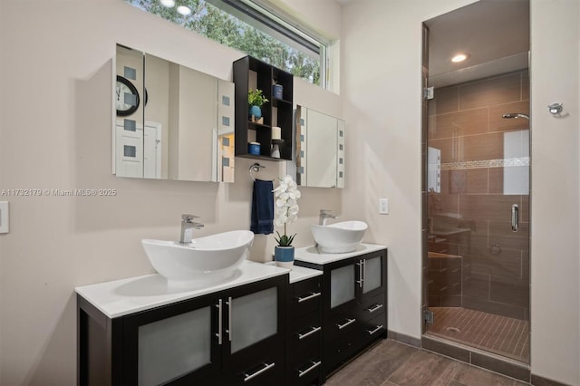 full bath with a stall shower, a sink, and double vanity