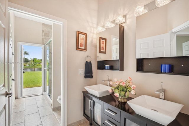 bathroom with a sink, a shower stall, toilet, and double vanity