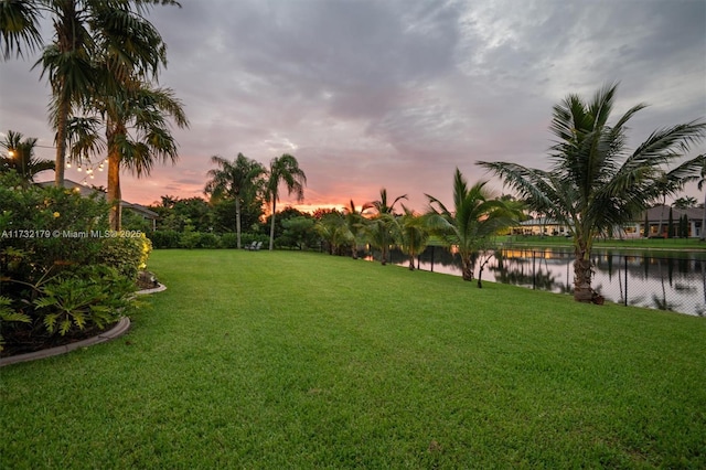 view of community featuring a water view and a yard