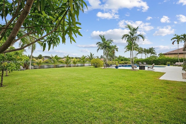 view of yard featuring a patio, a water view, and an outdoor pool