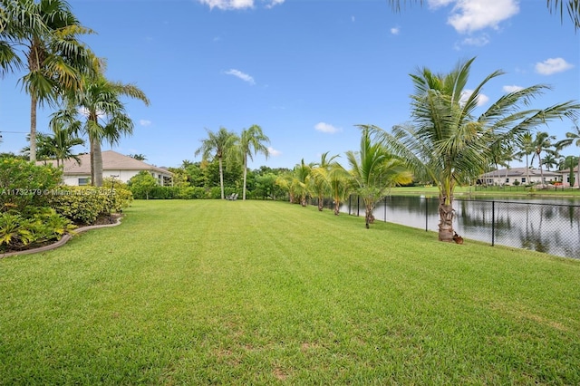 view of yard with a water view and fence