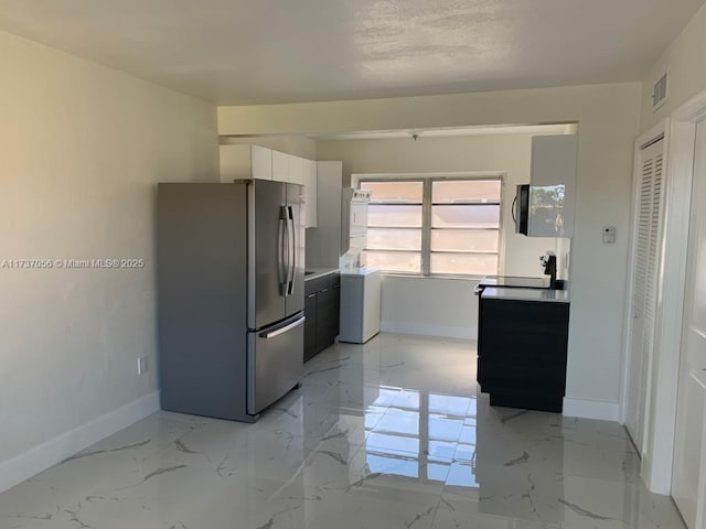 kitchen featuring white cabinetry and stainless steel fridge