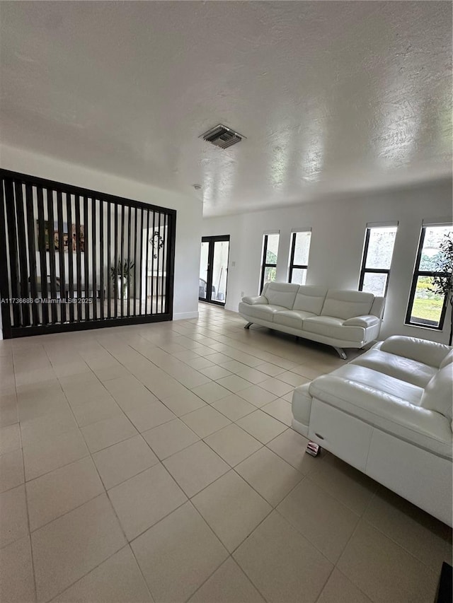 unfurnished living room featuring light tile patterned floors and a textured ceiling