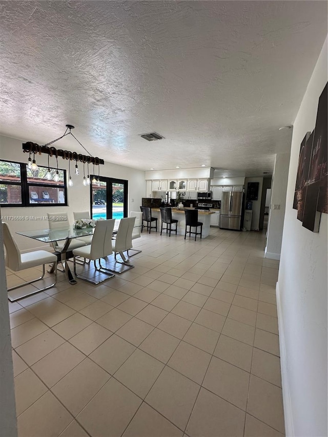 dining area with light tile patterned flooring and a textured ceiling