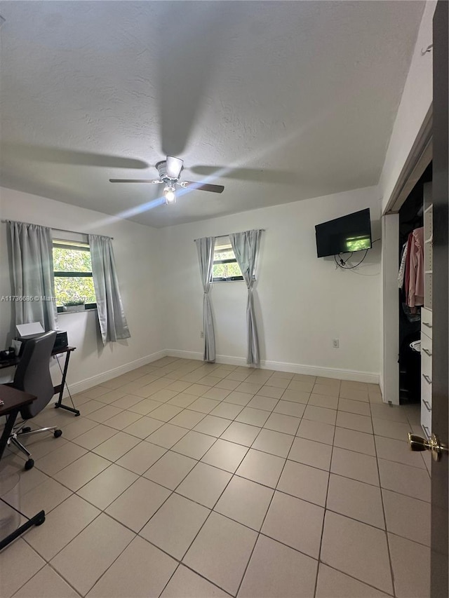 tiled office with ceiling fan and a textured ceiling