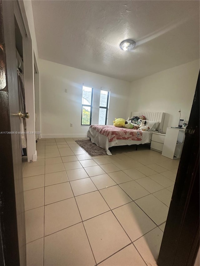 bedroom with light tile patterned floors and a textured ceiling