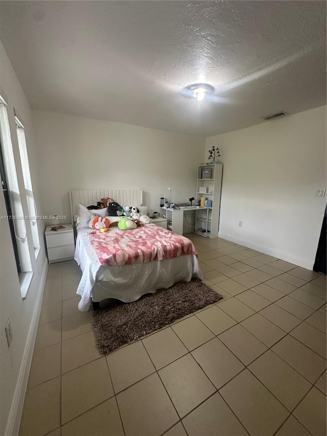 bedroom featuring light tile patterned flooring and a textured ceiling