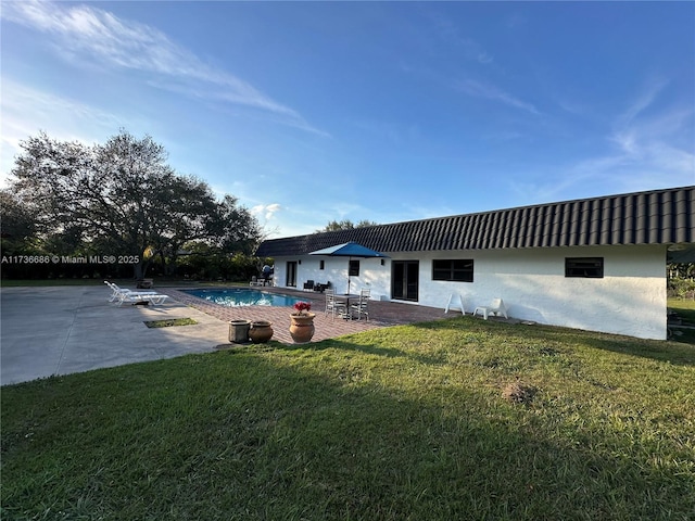 rear view of property with a patio area and a lawn