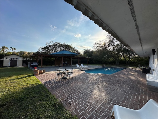 view of swimming pool featuring a storage shed, a gazebo, a lawn, and a patio area