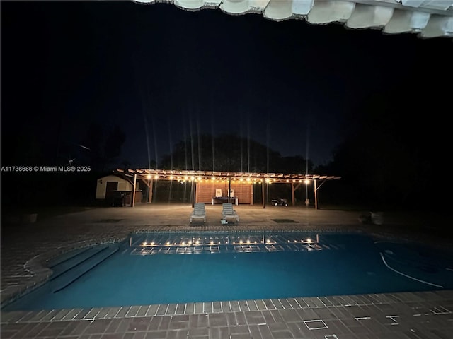 pool at twilight with a patio area