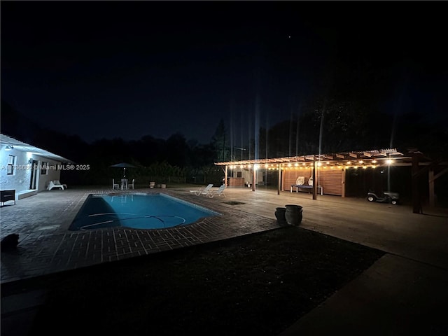 pool at twilight with a pergola and a patio area