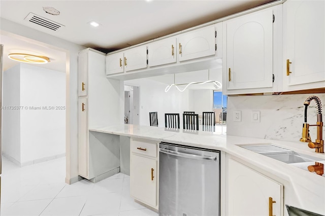 kitchen with white cabinetry, sink, decorative backsplash, stainless steel dishwasher, and light tile patterned floors