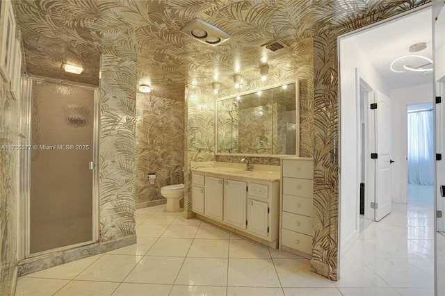 bathroom with tile patterned flooring, vanity, toilet, and walk in shower