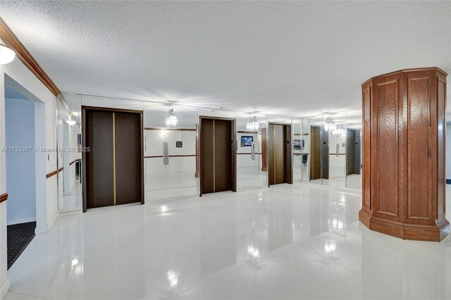 corridor featuring elevator and a textured ceiling