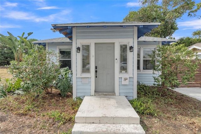 entrance to property with roof with shingles