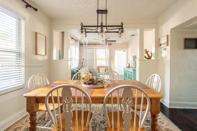 dining area with dark wood-type flooring and a textured ceiling