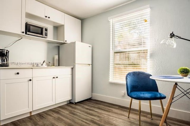 kitchen featuring hardwood / wood-style flooring, white fridge, sink, and white cabinets