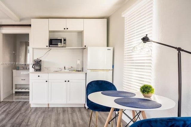 kitchen with white fridge, sink, light hardwood / wood-style flooring, and white cabinets