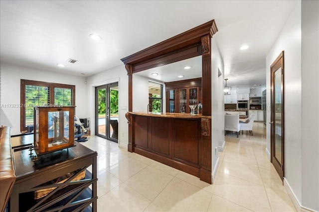 bar featuring oven, french doors, and light tile patterned flooring