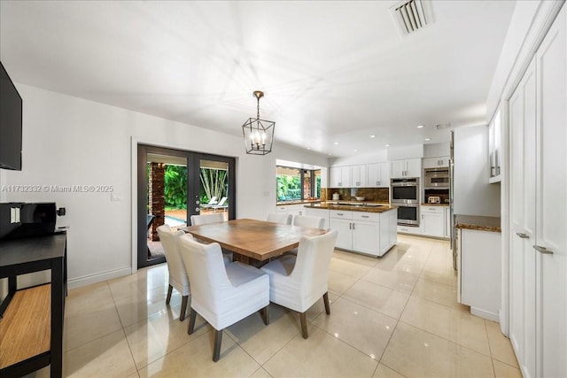 dining area with light tile patterned flooring and a chandelier