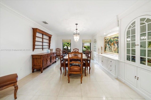 dining area with crown molding, light tile patterned flooring, and an inviting chandelier