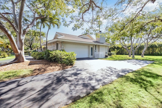7420 SW 145th Ter, Palmetto Bay, FL 33158 - view of home's exterior featuring central AC, a garage, and a lawn